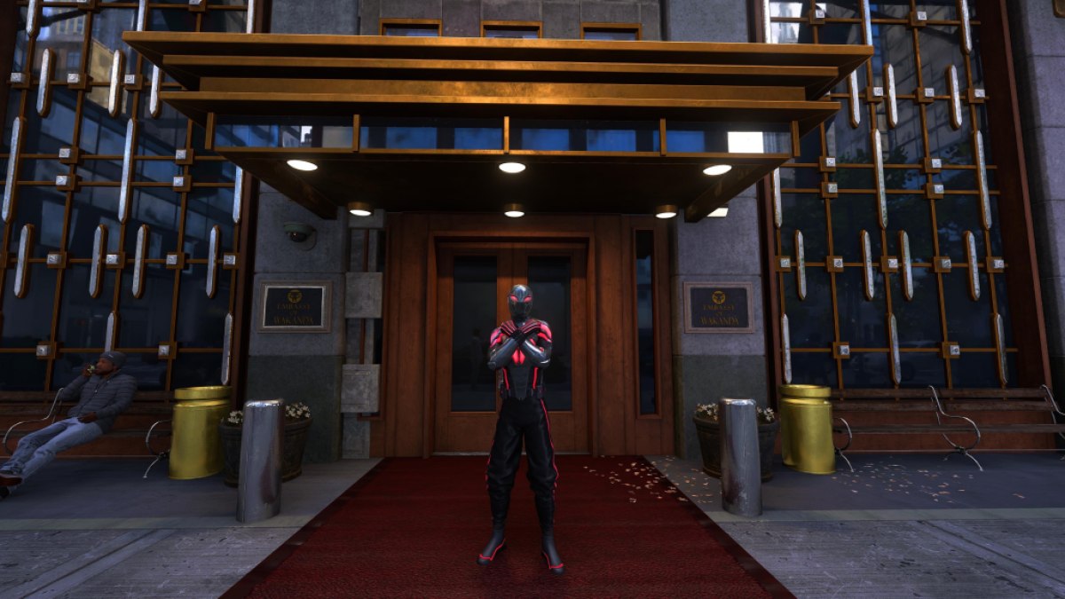 Ein Bild zeigt Miles Morales vor der Wakandan-Botschaft beim Wakandan-Gruß.  Er trägt seinen Anzug im Wakanda-Stil.  Das Bild ist Teil eines Artikels, der alle Anzüge für Miles Morales in Marvels Spider-Man 2 auflistet und erklärt, wie man sie freischaltet.