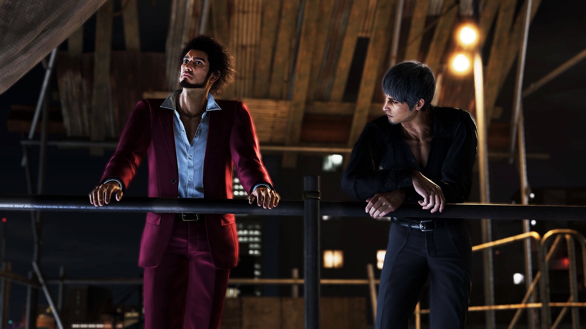 Image of Ichiban and Kiryu leaning on a metal railing overlooking the city at night and talking in Like a Dragon: Infinite Wealth.