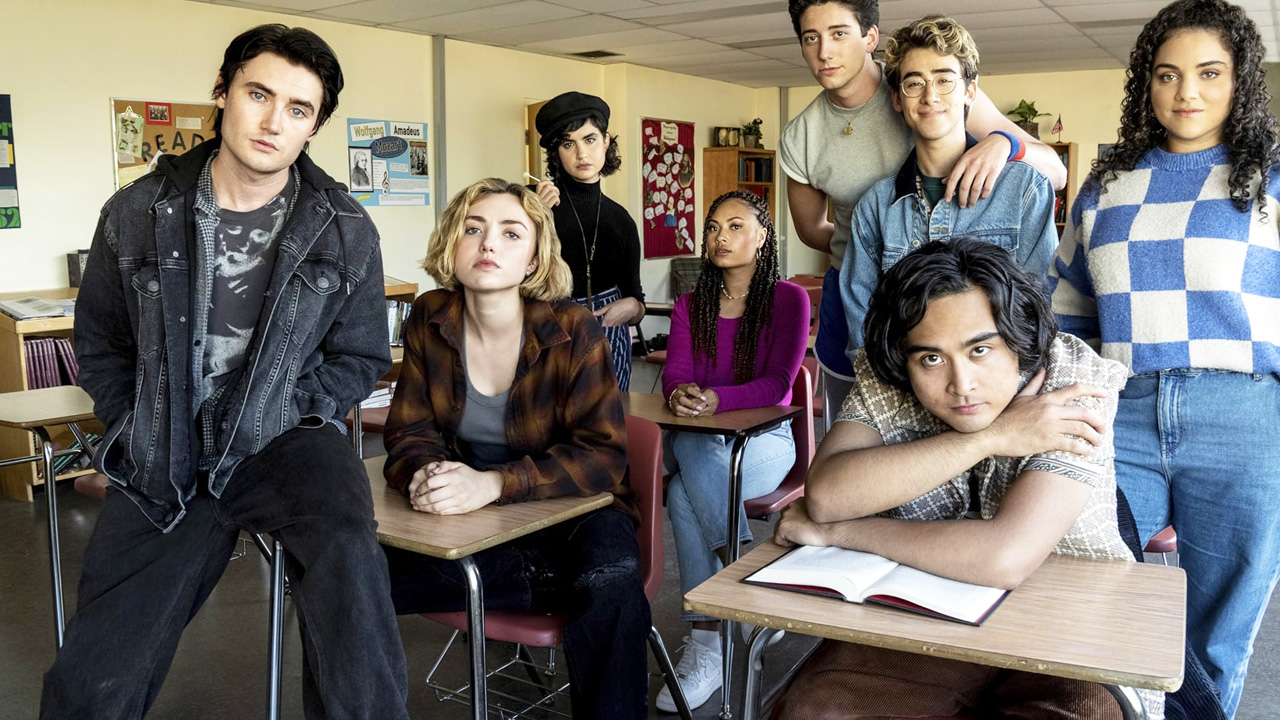 Several people sitting in a classroom, with different styles of dress.