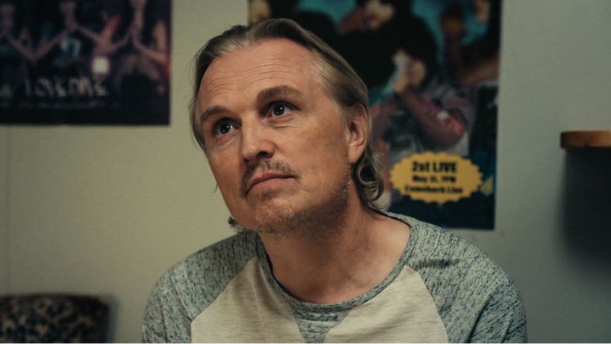 Posters on a wall behind a man in Night Country. This image is part of an article about what is True Detective: Night Country